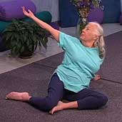 woman with white hair sitting on floor doing yoga pose